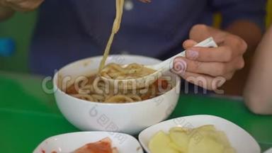 韩国餐馆里的年轻人吃传统的韩国面条